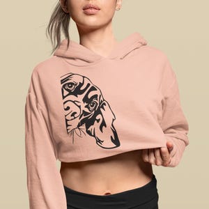 May include: A pink cropped hoodie with a black and white illustration of a dog's face on the front.
