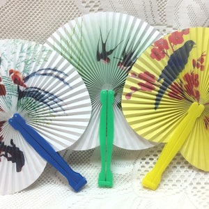 May include: Three paper folding fans with colorful designs. The fans are closed and have wooden handles. The fans are white, yellow, and green with bird and floral designs.