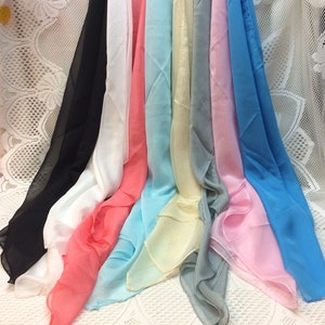 May include: A collection of eight sheer scarves in various colors, including black, white, coral, light blue, cream, gray, pink, and light blue. The scarves are arranged in a fan shape, with the black scarf at the bottom and the light blue scarf at the top.