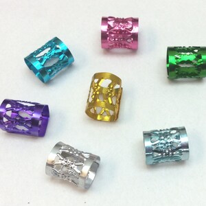 May include: Seven colorful metal hair beads with a decorative design. The beads are in shades of pink, blue, green, gold, purple, and silver.