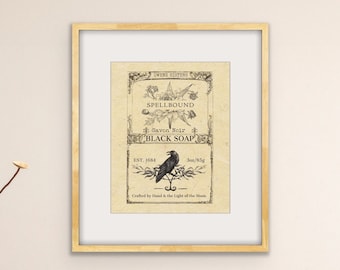 Könnte beinhalten: Ein gerahmter Druck eines Vintage-Etiketts für "Spellbound" schwarze Seife. Das Etikett zeigt einen schwarzen Raben, der auf einem Ast sitzt, mit dem Text "Crafted by Hand in the Light of the Moon" und "Est. 1884".
