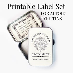 May include: Printable label set for Altoid type tins. The image shows two open rectangular tins with decorative designs and text. One tin has the text "Crystals whisper, subtle but strong, in the stillness, hear their song." The other tin has the text "Energize, protect, amplify, Crystal Keeper, Treasures for the Journey."