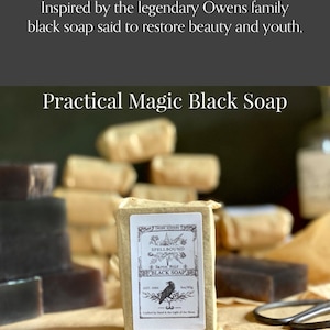 Op de afbeelding: Een blok Practical Magic Black Soap, verpakt in bruin papier, met een etiket met een ravenillustratie. De tekst op het etiket luidt "Spellbound Black Soap". Andere zeepblokken zijn op de achtergrond gestapeld.