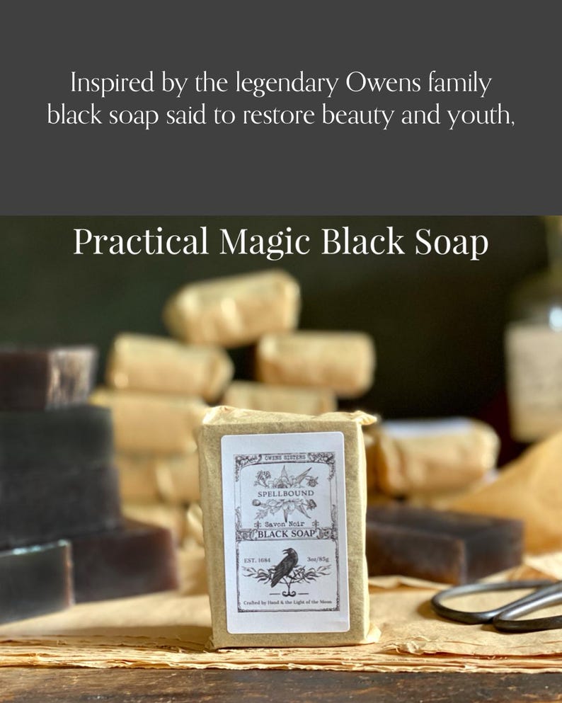 Op de afbeelding: Een blok Practical Magic Black Soap, verpakt in bruin papier, met een etiket met een ravenillustratie. De tekst op het etiket luidt "Spellbound Black Soap". Andere zeepblokken zijn op de achtergrond gestapeld.