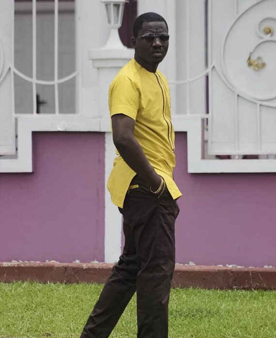 Profile side photo of positive cheerful afro american girl use cellphone  type blog post comment enjoy read feednews go walk wear striped t-shirt  brown pants trousers isolated yellow color background Photos |