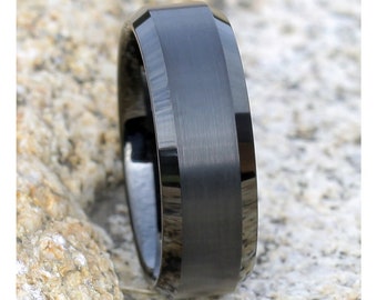 May include: A black tungsten carbide ring with a beveled edge and a brushed finish.