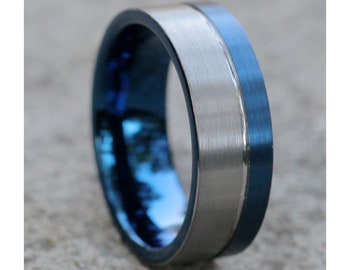 May include: A silver and blue tungsten carbide ring with a brushed finish. The ring has a blue band on the outside edge and a silver band in the center.