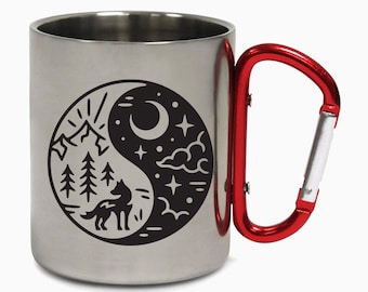 May include: A stainless steel travel mug with a red carabiner handle. The mug features a black and white yin yang design with a wolf, mountains, trees, a crescent moon, and stars.
