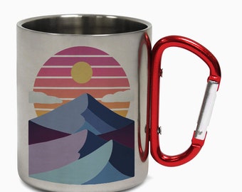 May include: A stainless steel travel mug with a red carabiner handle. The mug features a graphic of a mountain range with a sunset behind it. The sunset is a gradient of pink, orange, and yellow.