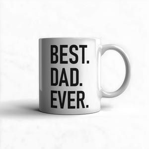 Peut inclure: Mug en céramique blanche avec l'inscription "BEST. DAD. EVER." en lettres noires grasses. La tasse a une anse incurvée et est posée sur un fond blanc. Un cadeau simple mais sincère.