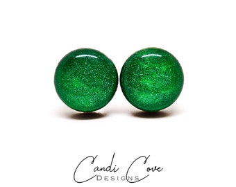 Op de afbeelding: Een paar groene glitter oorbellen. De oorbellen zijn rond en hebben een glanzende afwerking.