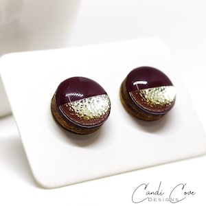 Round stud earrings with a unique two-toned design in burgundy and gold, featuring a hammered metal texture, adding a touch of edgy sophistication to any outfit. Western stud earrings by candi cove designs