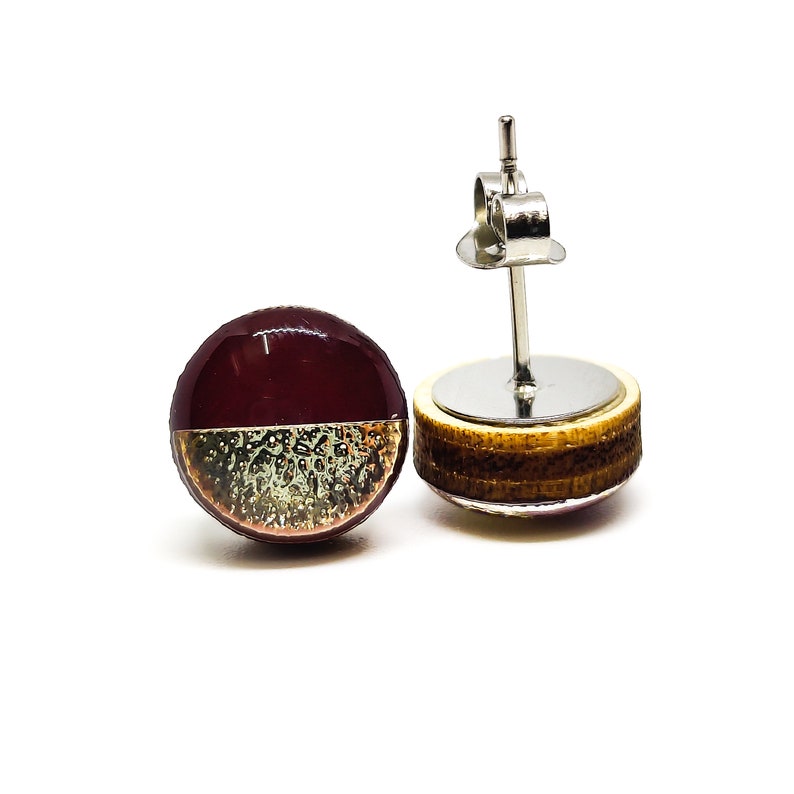 Round stud earrings with a unique two-toned design in burgundy and gold, featuring a hammered metal texture, adding a touch of edgy sophistication to any outfit. Western stud earrings by candi cove designs