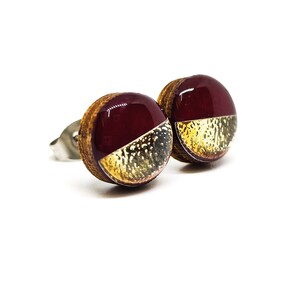 Round stud earrings with a unique two-toned design in burgundy and gold, featuring a hammered metal texture, adding a touch of edgy sophistication to any outfit. Western stud earrings by candi cove designs