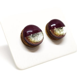 Round stud earrings with a unique two-toned design in burgundy and gold, featuring a hammered metal texture, adding a touch of edgy sophistication to any outfit. Western stud earrings by candi cove designs