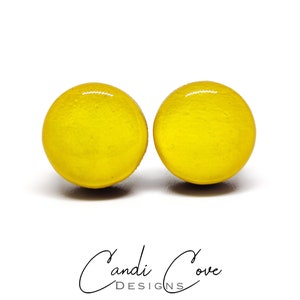 May include: A pair of yellow round stud earrings. The earrings are made of wood and have a glossy finish.