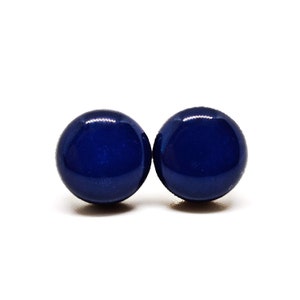 May include: A pair of dark blue round stud earrings.