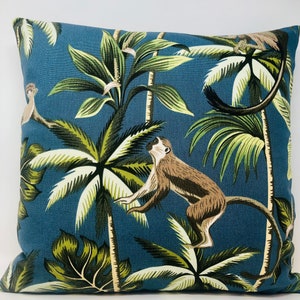 May include: A blue throw pillow with a tropical print featuring monkeys and palm trees.