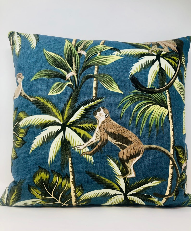 May include: A blue throw pillow with a tropical print featuring monkeys and palm trees.