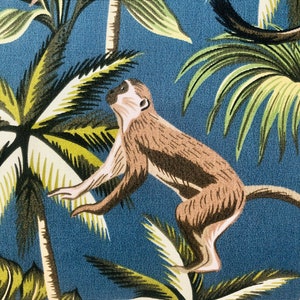 May include: A blue and green tropical print fabric with a brown monkey jumping between palm trees.