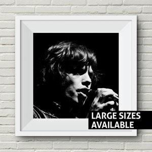 Puede incluir: Fotografía en blanco y negro de un músico cantando en un micrófono. El músico tiene el pelo largo y lleva una camisa oscura. El texto "LARGE SIZES AVAILABLE" está impreso en la parte inferior de la imagen.