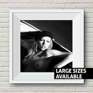 Peut inclure: Photographie en noir et blanc d'une femme portant un b&eacute;ret noir. Elle est assise dans une voiture et regarde directement la cam&eacute;ra. Le texte "LARGE SIZES AVAILABLE" est imprim&eacute; en bas de l'image.