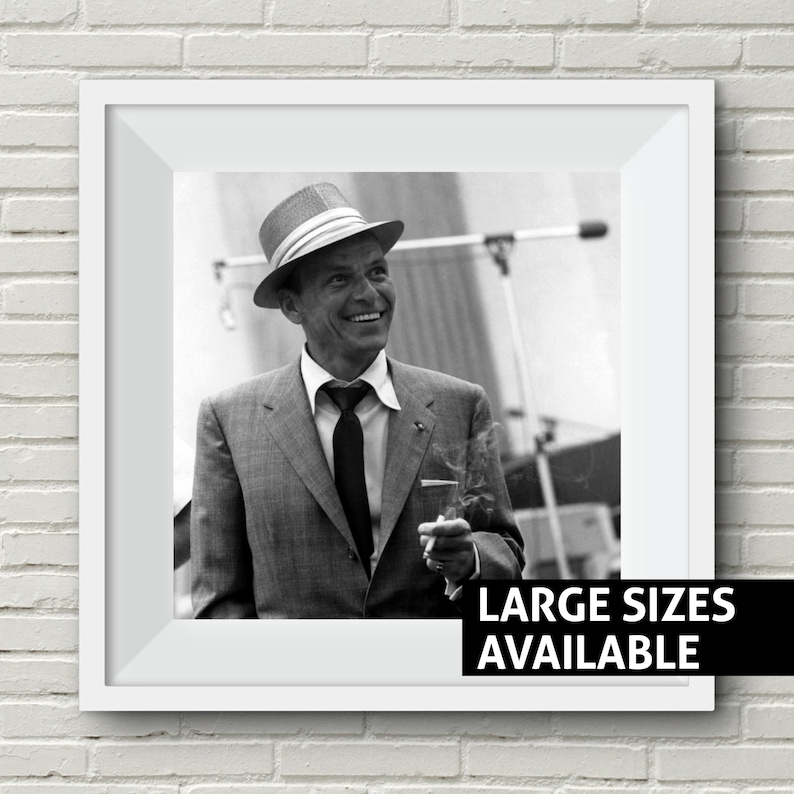May include: Black and white photo of a man wearing a hat and suit, smiling and holding a cigarette. The text "LARGE SIZES AVAILABLE" is at the bottom of the image.