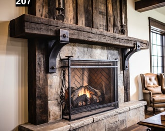 Puede incluir: Una chimenea rústica con base de piedra y repisa de madera. La chimenea tiene una pantalla de metal negro y un fuego encendido en su interior. La repisa está sostenida por soportes de metal negro. La pared detrás de la repisa es de tablones de madera. El número "207" está en la esquina superior izquierda.