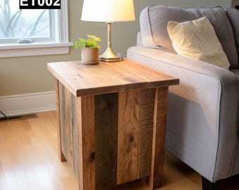 May include: A rustic wooden end table with a natural wood finish. The table has a rectangular top and is supported by four legs. The table is sitting next to a gray couch with a white pillow.