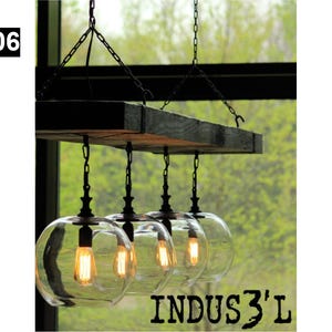 May include: A rustic farmhouse style chandelier with four clear glass globe shades hanging from a wooden beam. The chandelier is suspended by black chains and has a rustic, industrial look.