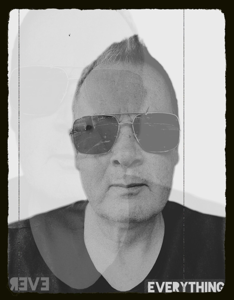 Op de afbeelding: Zwart-wit portret van een persoon met een zonnebril. De afbeelding heeft een dubbele belichting, met een vervaagde afbeelding van dezelfde persoon op de achtergrond. Het woord "EVERYTHING" is zichtbaar onderaan.