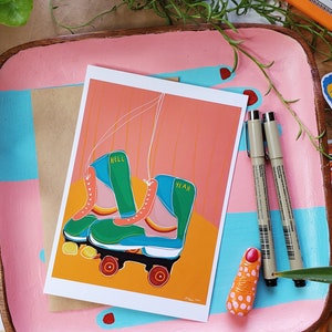 Puede incluir: Una tarjeta de felicitaci&oacute;n con una ilustraci&oacute;n colorida de un par de patines. Los patines son verdes, azules y rosas con ruedas amarillas. El texto "Hell Yeah" est&aacute; escrito en los patines.