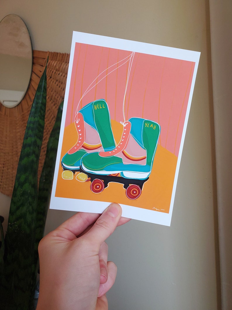 Puede incluir: Un par de patines de ruedas verdes y azules con ruedas blancas y detalles naranjas. Los patines tienen las palabras "Hell Yeah" escritas en ellos.
