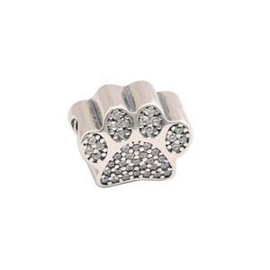 May include: Silver charm in the shape of a paw print with clear cubic zirconia stones.