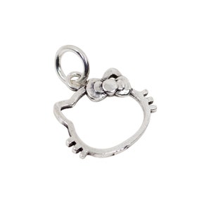 Op de afbeelding: Een zilverkleurige bedel in de vorm van een cartoon kattenkop, met een strik en een lus om aan een ketting of armband te bevestigen. De bedel heeft een eenvoudig, omlijnd ontwerp en staat tegen een witte achtergrond.