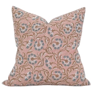 Peut inclure: Un oreiller rose avec un motif floral dans les tons de brun et de bleu. L'oreiller est fait d'un tissu doux et confortable et a une forme carrée.