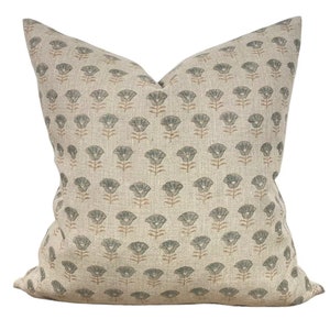 May include: A beige pillow with a floral pattern in shades of green and brown. The pillow is made of a linen fabric and has a square shape.