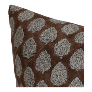 May include: A brown pillow with a white and black leaf pattern.