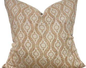 May include: A beige throw pillow with a brown geometric pattern of circles and leaves. The pillow is made of a linen fabric.