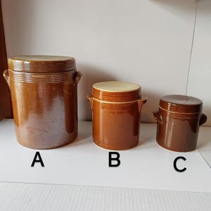 May include: Three brown ceramic jars with lids, labelled A, B, and C. The jars are different sizes, with jar A being the largest and jar C being the smallest.