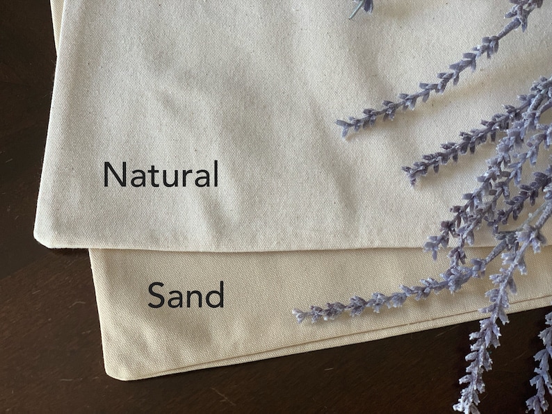 May include: Two pieces of fabric, one labeled "Natural" and the other labeled "Sand". The fabric is a natural off-white color.