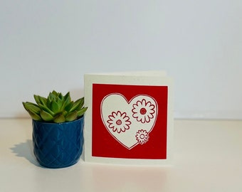 Red heart Valentine's Day card with a flower design.