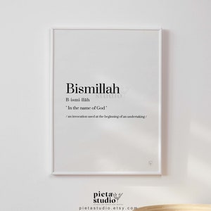 Op de afbeelding: Een wit ingelijst afdruk met het Arabische woord "Bismillah" in zwarte tekst, wat "In de naam van God" betekent. De afdruk bevat ook de transliteratie van het woord en een beschrijving van de betekenis. De afdruk is van de winkel "pieta studio".