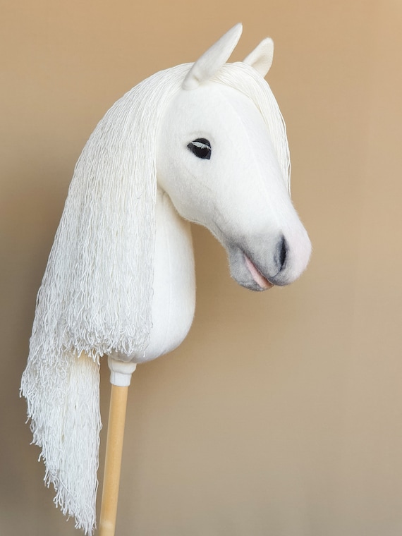 White hobby horse on a stick with leather bridle, halter, comb,brush, carrot ,equine passport for hobby horsing outdoor play and competition