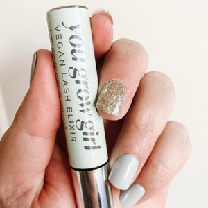 May include: A silver tube with a green label that reads "You Grow Girl Vegan Lash Elixir".