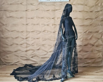 May include: A black tulle wedding veil with a lace trim. The veil is long and flowing, and it is shown draped over a mannequin.