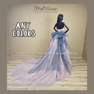 May include: A mannequin wearing a layered gown with a long train. The dress features a pink bodice, a blue bow, and layers of pink and blue tulle. The text "ANY COLORS" is displayed in large white letters.