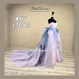 May include: A strapless, floor-length gown in shades of pink and blue, displayed on a mannequin. The dress features a layered skirt and a long train. The text "ANY COLORS" is visible in the image.