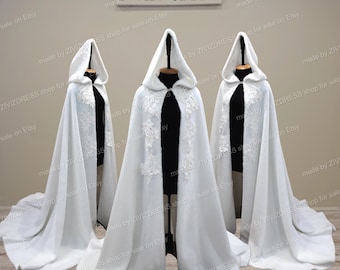 May include: Three white hooded capes with lace detailing. The capes are lined with a soft white fabric. The capes are made by ZIVIZDRESS shop for sale on Etsy.