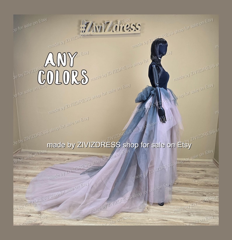 May include: A layered tulle skirt in shades of lavender, grey, and navy blue, with a long train. The skirt is displayed on a black mannequin. The text "ANY COLORS" is visible.